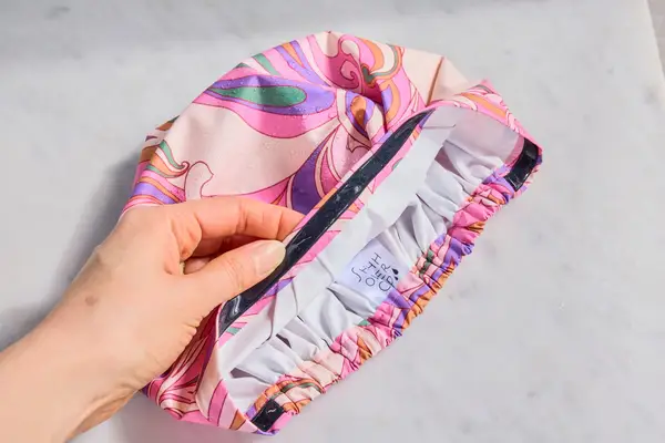 A pink SHHHOWERCAP on a bathroom counter