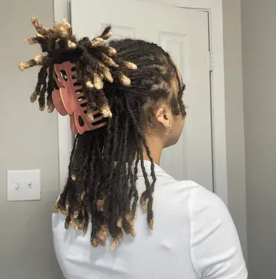 A woman with her dark hair pulled half-up, half-down with a pearly claw clip