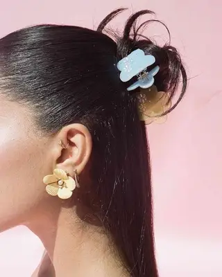 A slicked-back half-up, half-down bun with butterfly clips