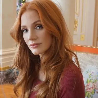 Jessica Chastain with bright copper hair and radiant neutral makeup