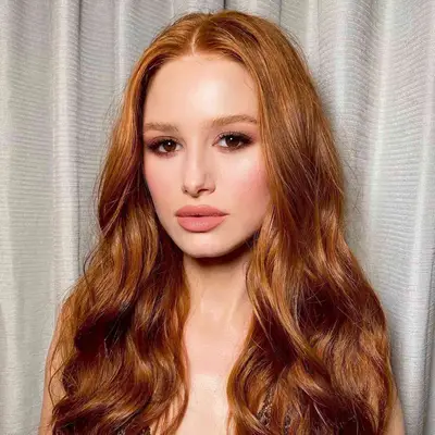 Madelaine Petsch with glossy red hair and glowing peachy skin