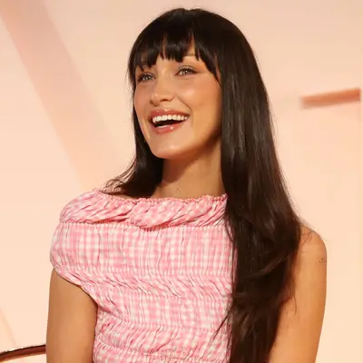 Bella Hadid with espresso-colored hair with bangs and radiant medium tan skin