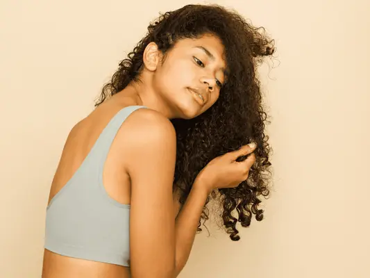 Image of woman touching her curly hair