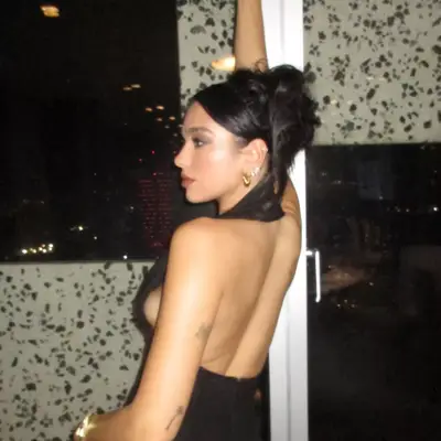 Dua Lipa with her hair in a messy updo bun