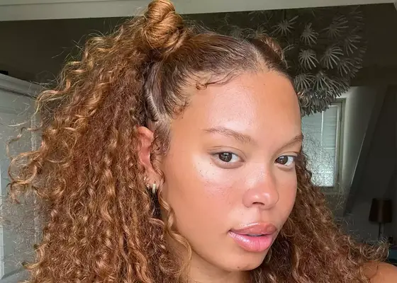 Woman with long curly ginger hair and two space buns on top 