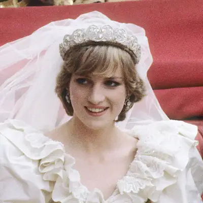 Princess Diana wears a long, flat fringe beneath her tiara-topped vail