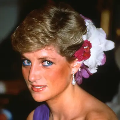 Princess Diana wears silk flowers in her hair and a one-shoulder chiffon evening dress designed by Catherine Walker to a dinner in Bangkok, 1988