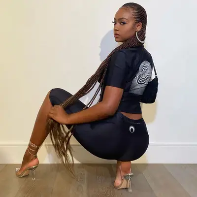 Justine Skye poses with long cornrows and silver heels