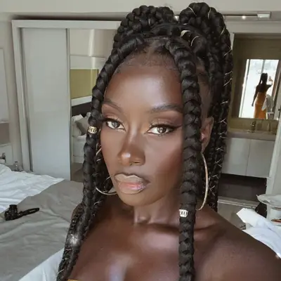 Woman with ponytail jumbo braids and gold jewelry