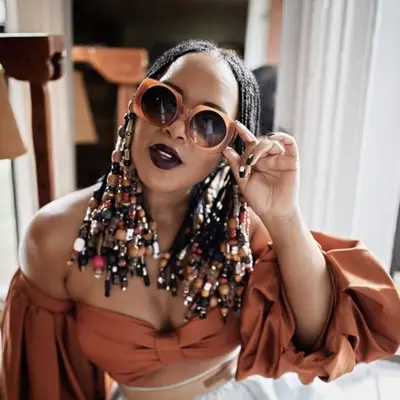 Woman with beaded Fulani braids and big sunglasses