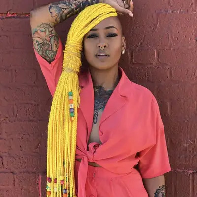 Woman with long yellow box braids with beads
