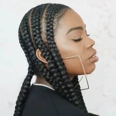 Woman with jumbo feed-in braids and big earrings