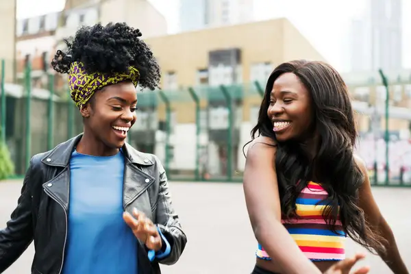 Two black women, one with natural hair and one whose hair has been texlaxed