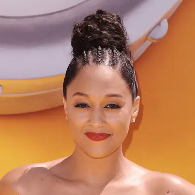 Tia Mowry wearing curly bun with cornrows in the front