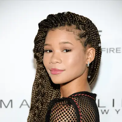 Storm Reid wearing a side twist hairstyle and long box braids