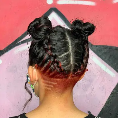 Back view of woman with two braided space buns and a patterned red undercut
