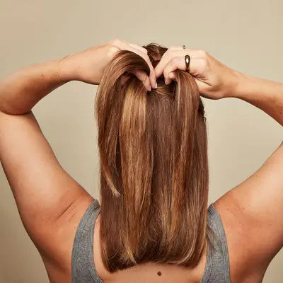 Model begins French braiding her hair