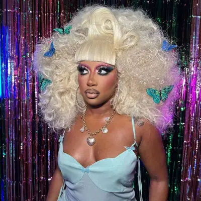 A hairstyle with blunt bangs, voluminous curls and floating butterflies.