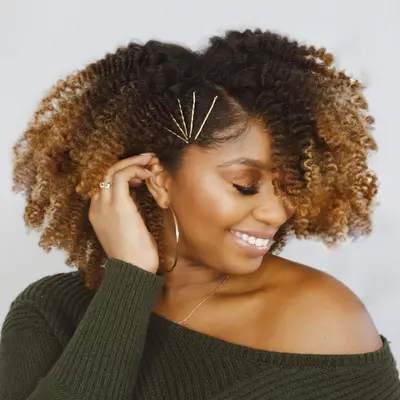 Courtney Danielle wearing dark-to-bronde ombré natural curls with gold pins