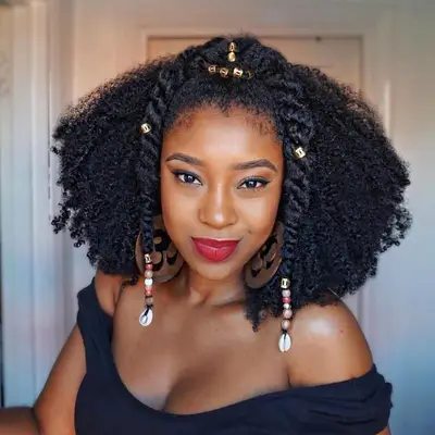 A woman wearing natural curls with beads and a decorative twisted braid