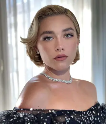 Florence Pugh with romantic, sweeping bixie cut and diamond choker necklace in off-the-shoulder gown