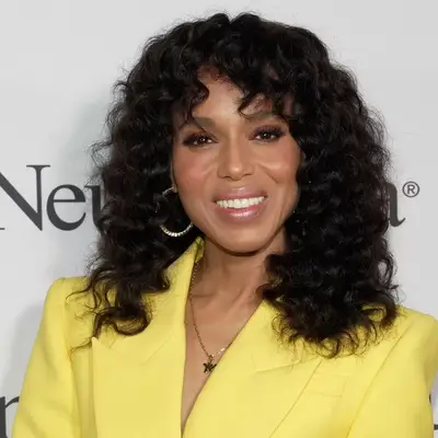 Kerry Washington with curly shag and bangs wearing yellow suit