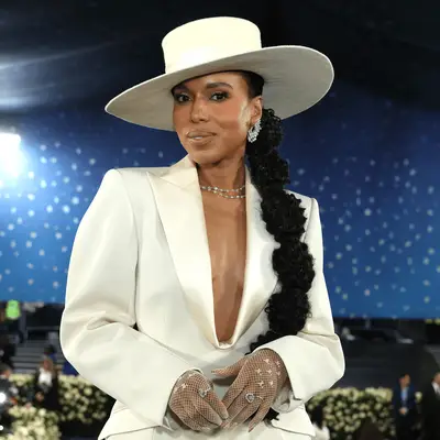 Kate Hudson in an elegant event setting, wearing a necklace and styled hair