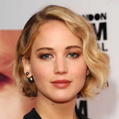 Jennifer Lawrence wears soft dissheveled curls for a modern hollywood glam style on her highlighted bob
