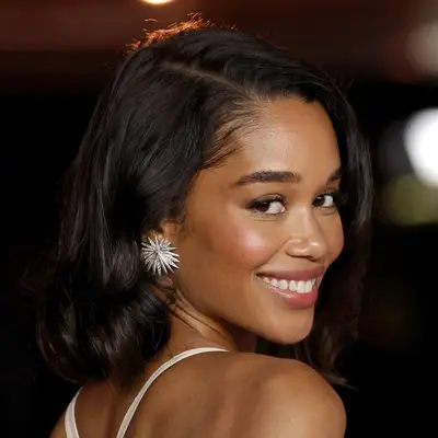 Laura Harrier look sover her shoulder wearing a side parted old Hollywood styled long bob