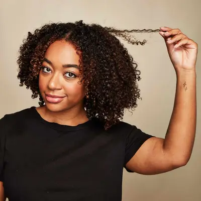 Woman holds one of her curls up