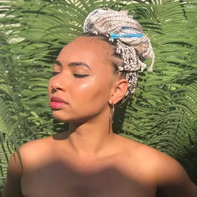 Woman with blue and white box braids updo in sunshine