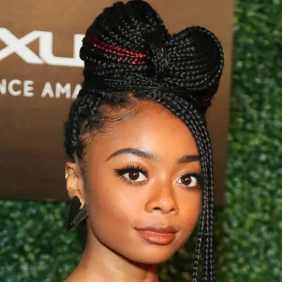 Skai Jackson wears box braids in a bun with face-framing free ends