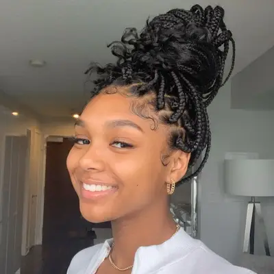 Woman with box braids in loose topknot updo