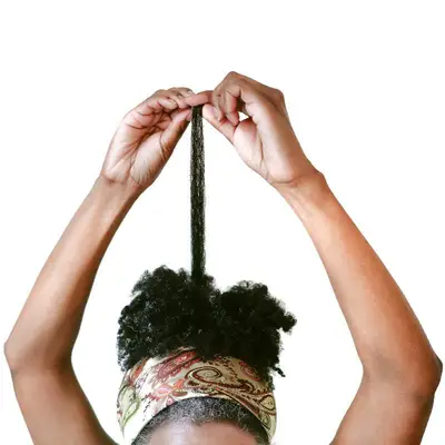 Woman pulling a few strands of her natural hair up