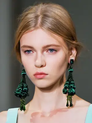 statement earrings hairstyles: woman with loose ponytail