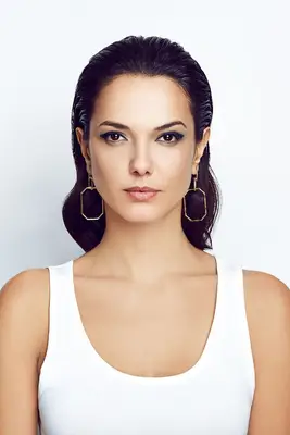 statement earrings hairstyles: woman with slicked back hair