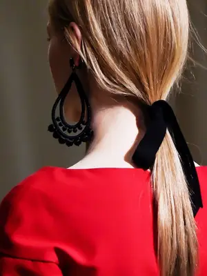 statement earrings hairstyles: woman with ribbon ponytail