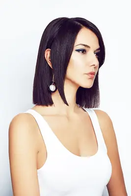 statement earrings hairstyles: woman with hair tucked behind ear