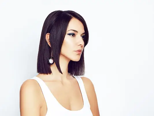 statement earrings hairstyles: woman with hair tucked behind ear