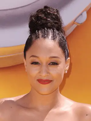 Tia Mowry in slicked back loose hair bun with three cornrows at the base