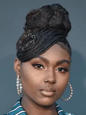 Tiana Major9 in knotless box braids with high woven bun and swoop bang
