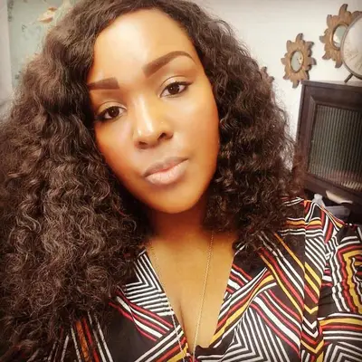 Person wears a naturally curly asymmetrical bob