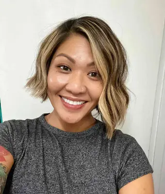 Person with honey blonde wavy asymmetrical bob