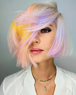 Person with rainbow pastel and platinum blonde asymmetrical bob