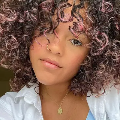 Woman with light pink ombré natural curls