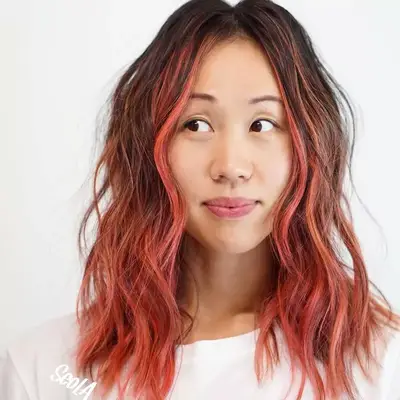 Woman wears medium-length pink ombré hair with face-framing balayage