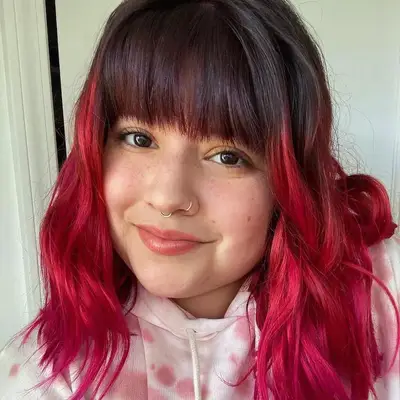 Woman with pink ombré hair and natural dark bangs