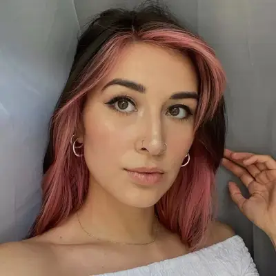 Woman with face-framinglight pink ombré hair on dark base