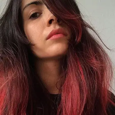 Woman with voluminous scarlet-toned pink ombré hair