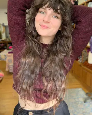 Person with a super long, curly shag haircut